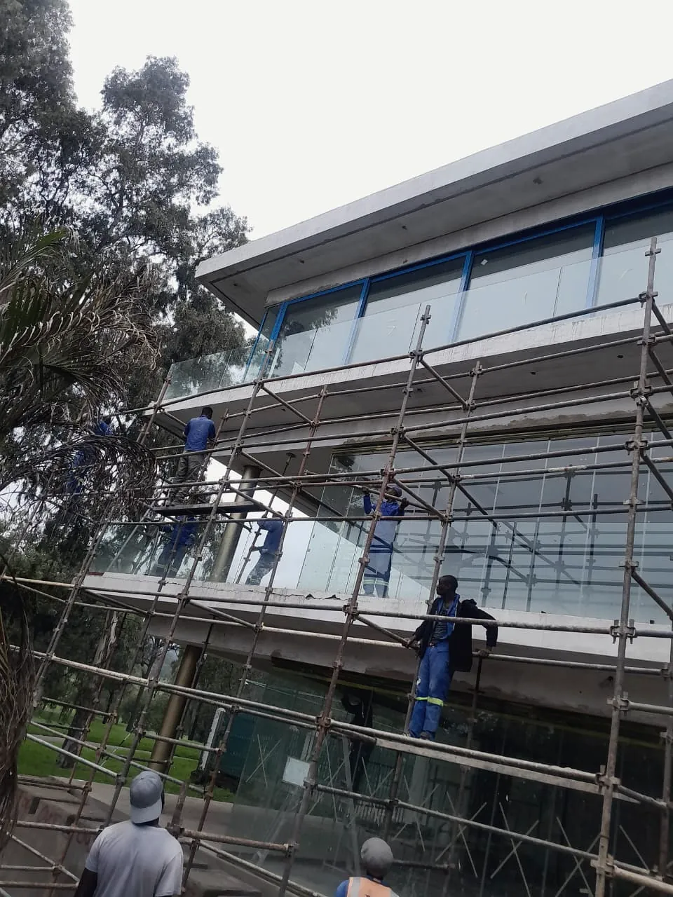 Commercial building with glazed facade and scaffolding during finishing works
