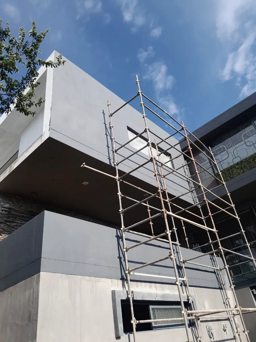 Scaffolding erected against a modern commercial building under construction