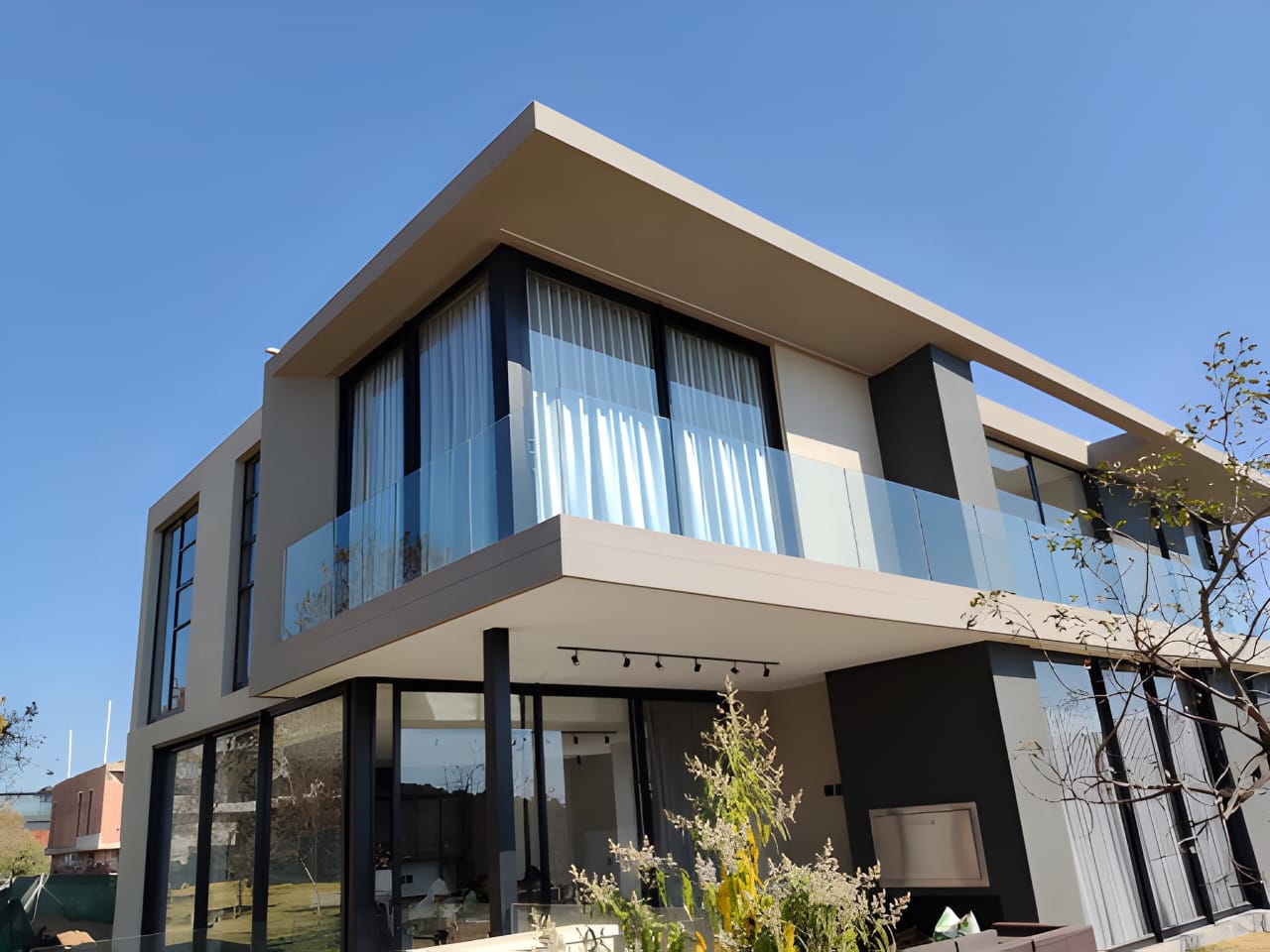 Completed contemporary home with glass balustrades and cantilevered roof