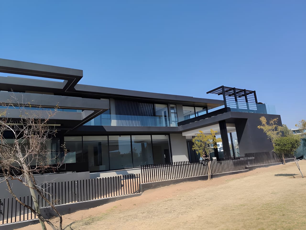 Modern architectural residence with steel and glass detailing under a clear sky